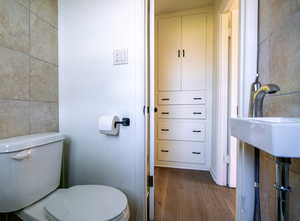 Bathroom with dark wood finished floors and tile walls