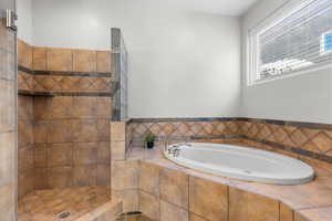 Full bathroom with a bath and a tile shower