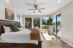 Bedroom with wood finished floors, multiple windows, access to outside, recessed lighting, and a ceiling fan