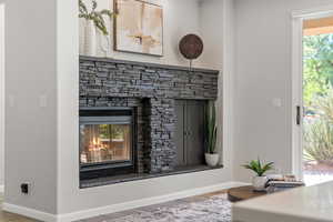 Detailed view of wood finished floors and a stone fireplace