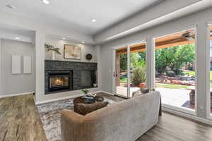 Living area featuring wood finished floors, a fireplace, recessed lighting, and a ceiling fan