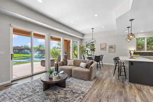 Living room with light wood-style floors, recessed lighting, and a raised ceiling
