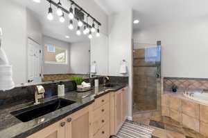 Bathroom featuring a bath, double vanity, a stall shower, and recessed lighting