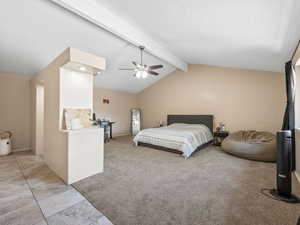 Bedroom with light colored carpet, ceiling fan, and light tile patterned flooring