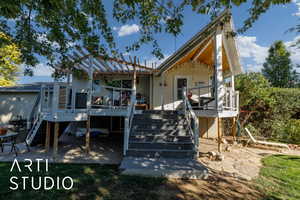 Back of house with stairway, a patio area, and a wooden deck