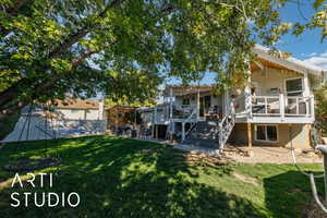 Rear view of property featuring a patio area, stairs, and a deck