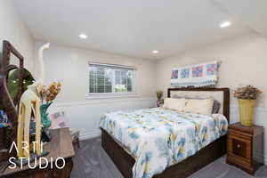 Carpeted bedroom with wainscoting and recessed lighting