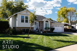 Tri-level home with brick siding, a front lawn, concrete driveway, a shingled roof, and a garage