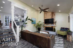 Living area with a fireplace, ceiling fan, dark wood finished floors, recessed lighting, and stairway