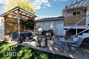 View of patio featuring a hot tub, stairway, and area for grilling