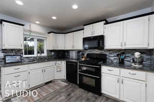 Kitchen featuring black appliances, dark stone counters, white cabinetry, backsplash, and recessed lighting