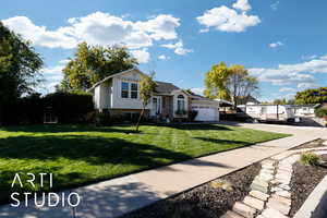 Tri-level home featuring concrete driveway, an attached garage, and brick siding