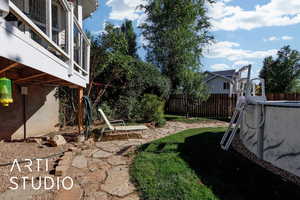 Fenced backyard featuring a patio and a balcony