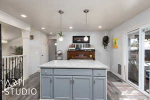 Kitchen featuring a kitchen island, dark wood finished floors, gray cabinets, decorative light fixtures, and recessed lighting