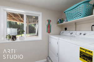 Laundry area with separate washer and dryer and baseboards