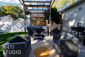 View of patio / terrace with a hot tub, grilling area, and a pergola