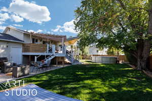 Fenced backyard featuring stairway, a deck, a patio area, an outdoor pool, and a pergola