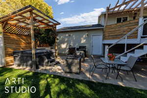 View of patio with a hot tub, stairway, and grilling area