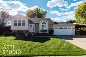 Split level home with brick siding, driveway, a shingled roof, and a garage