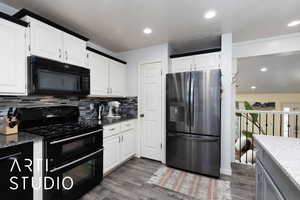 Kitchen with black appliances, dark stone countertops, recessed lighting, and dark wood-style floors