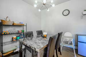 Dining space with a chandelier and dark wood-style flooring