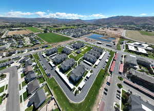 Aerial view of property and surrounding area featuring nearby suburban area and a water and mountain view