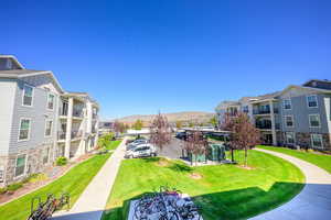 View of property's community featuring a mountain view, a yard, and a residential view