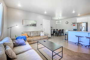 Living area featuring light wood-style flooring, a chandelier, and recessed lighting