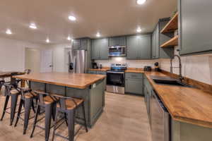 Downstairs kitchen with brand new appliances, butcher block countertops, and custom cabinets