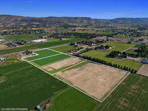 Overview of rural landscape featuring a mountainous background and property boundaries highlighted