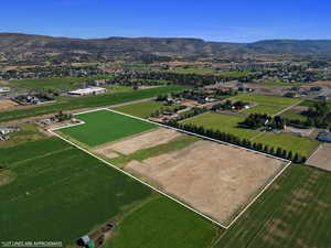 Overview of rural landscape featuring a mountain backdrop and property boundaries highlighted