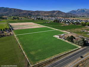 Aerial view of sparsely populated area featuring property boundaries highlighted and a mountain backdrop