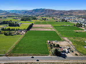 View of rural area with a mountain backdrop and large plots for crops