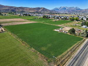 Aerial view of sparsely populated area with a mountain backdrop and farmland