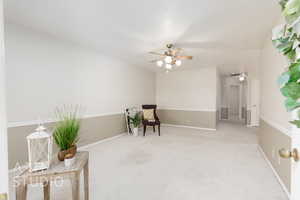 Sitting room with carpet and a ceiling fan