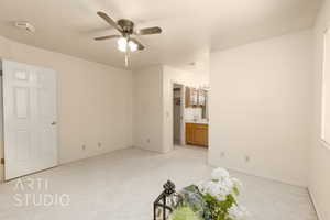 Unfurnished bedroom featuring light colored carpet, a ceiling fan, and ensuite bathroom