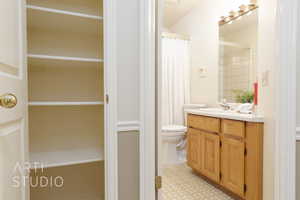 Bathroom featuring vanity, a shower with curtain, and a spacious closet