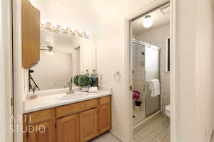Bathroom featuring a stall shower, vanity, and a ceiling fan