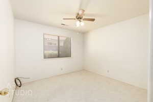 Spare room featuring carpet and ceiling fan