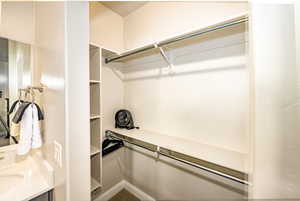 Primary walk in closet with a sink