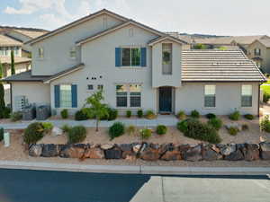 View of front facade featuring stucco siding and a tile roof