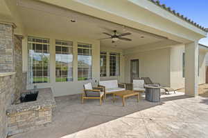View of patio featuring a ceiling fan and an outdoor living space
