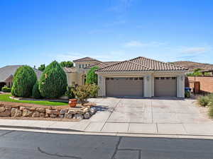 Mediterranean / spanish-style house featuring stucco siding, driveway, a tile roof, and an attached garage