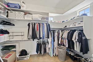 Spacious closet featuring light colored carpet