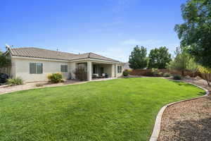 Rear view of house with a fenced backyard, stucco siding, a patio area, a tile roof, and an outdoor hangout area