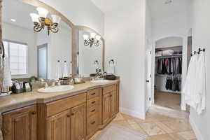 Bathroom with double vanity, recessed lighting, a chandelier, and a spacious closet