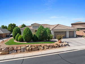 Mediterranean / spanish-style house featuring driveway, a tiled roof, stucco siding, and a garage
