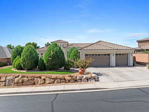 Mediterranean / spanish home featuring driveway, stucco siding, a tiled roof, and an attached garage