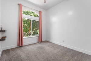 Spare room featuring carpet and a ceiling fan