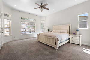 Carpeted bedroom featuring ceiling fan and recessed lighting
